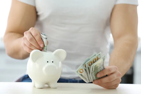 Joven insertando dinero —  Fotos de Stock