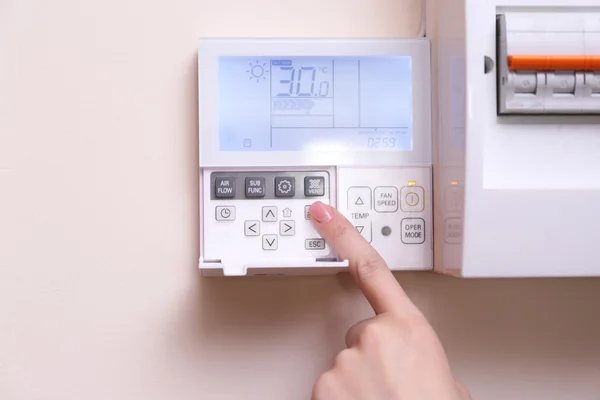 Woman switching a digital thermostat — Stock Photo, Image