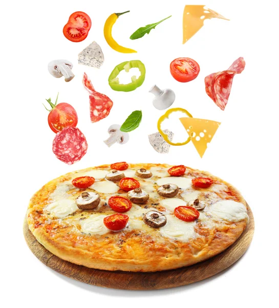 Tasty pizza decorated with falling ingredients — Stock Photo, Image