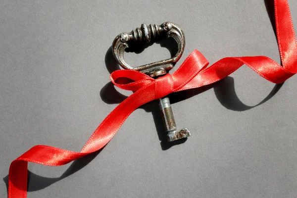 Vintage key with a red ribbon — Stock Photo, Image