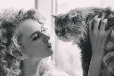 Genç kadın ve kedi odada.