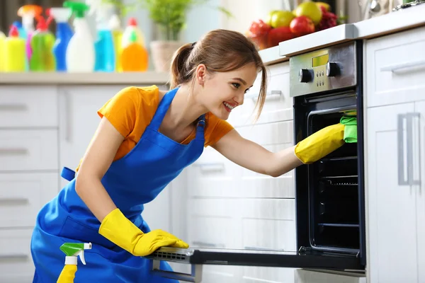 Frau wäscht Ofen — Stockfoto