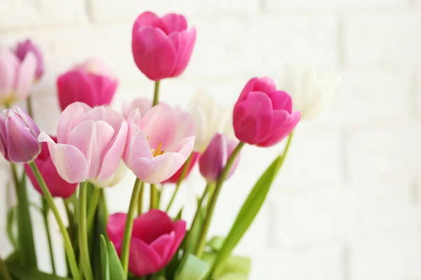 Hermosos tulipanes sobre fondo de pared de ladrillo — Foto de Stock