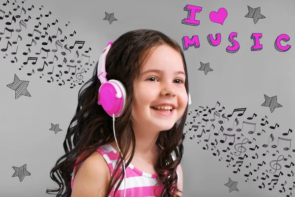 グレーの背景にピンクのヘッドフォンで魅力的な少女 — ストック写真
