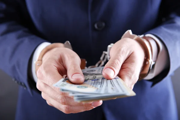 Чоловік в наручниках підрахував доларові банкноти — стокове фото