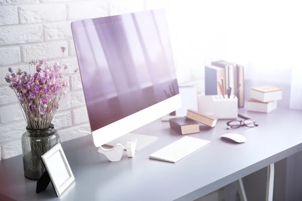 Wooden table with flowers and computer