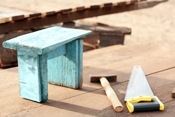 Taburete de madera pequeño, martillo y sierra . —  Fotos de Stock