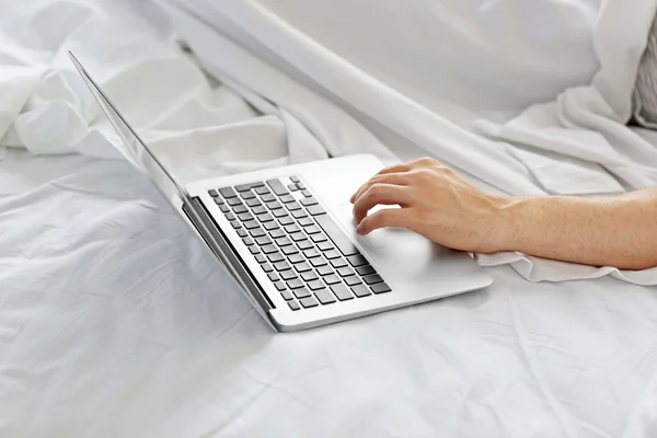 Uomo sdraiato a letto con laptop — Foto Stock