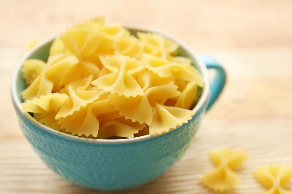 Dry farfalle pasta in blue cup — Stock Photo, Image