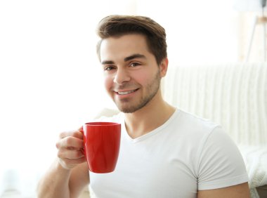 adam kırmızı fincan kahve ile