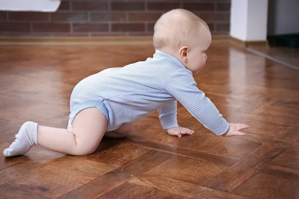 Kruipende baby op de houten vloer — Stockfoto