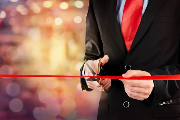 Businessman cutting red ribbon — Stock Photo, Image