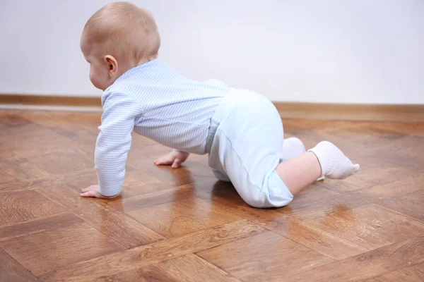 Kruipende baby op de houten vloer — Stockfoto