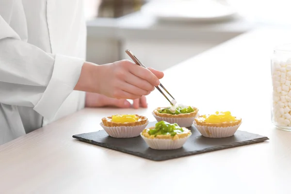 Mani di chef decorare crostate di frutta — Foto Stock