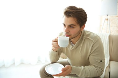 Yakışıklı adam kahve içiyor.