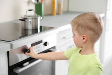 Mutfak elektrikli soba ile oynayan küçük çocuk