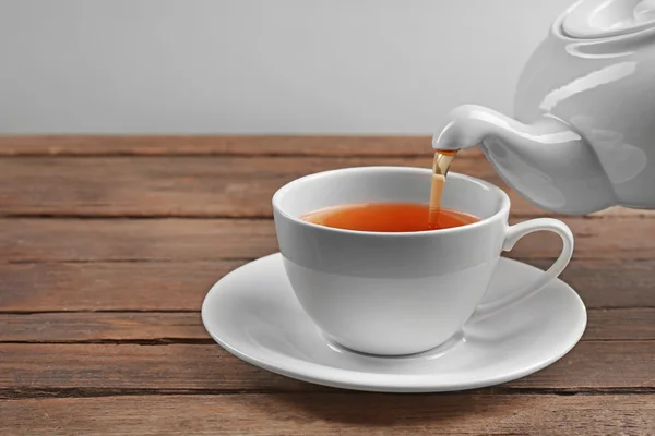 Šálek čaje na dřevěném stole — Stock fotografie
