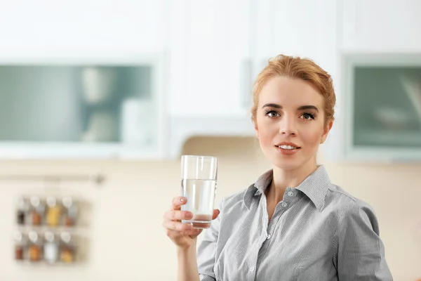 Wanita muda di dapur minum air — Stok Foto