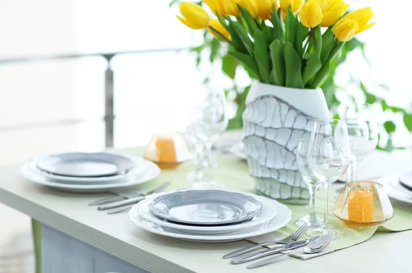 Tafel geserveerd en een boeket tulpen — Stockfoto