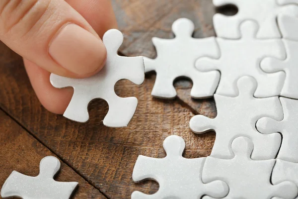 Woman playing with jigsaw puzzle — Stock Photo, Image