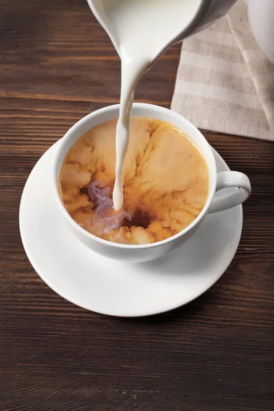 Milk poured into cup of tea — Stock Photo, Image
