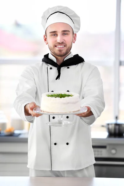 Männlicher Koch hält Kuchen. — Stockfoto