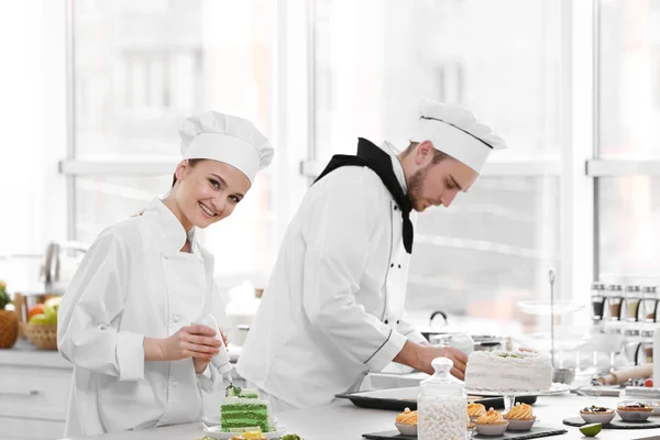 Mannelijke en vrouwelijke chef-koks werken — Stockfoto