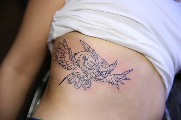 Female body with bird tattoo