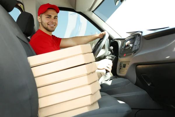 Мужчина сидит в машине с пиццей — стоковое фото