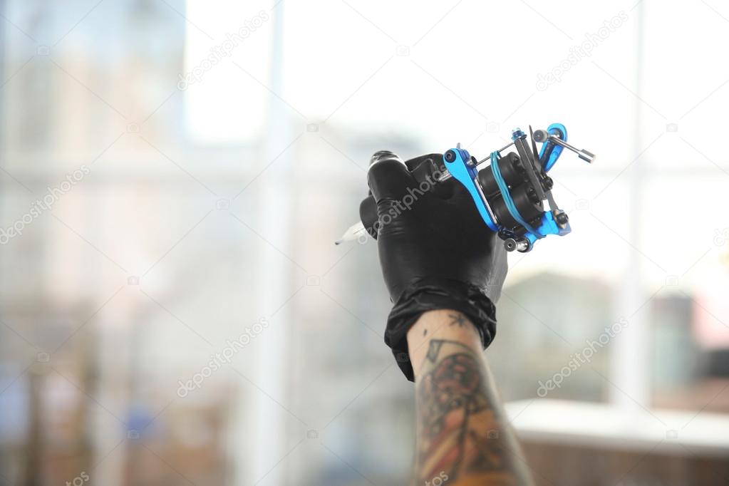 Man's hand holding tattoo machine — Stock Photo © belchonock 110366370