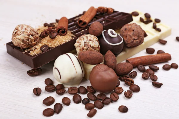 Spilled sugar and coffee beans with chocolates — Stock Photo, Image