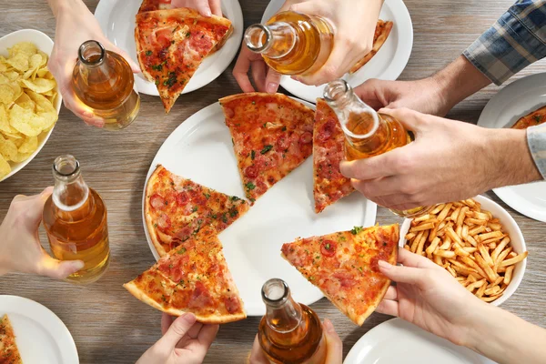 Vriendelijke partij met hete pizza en dranken — Stockfoto