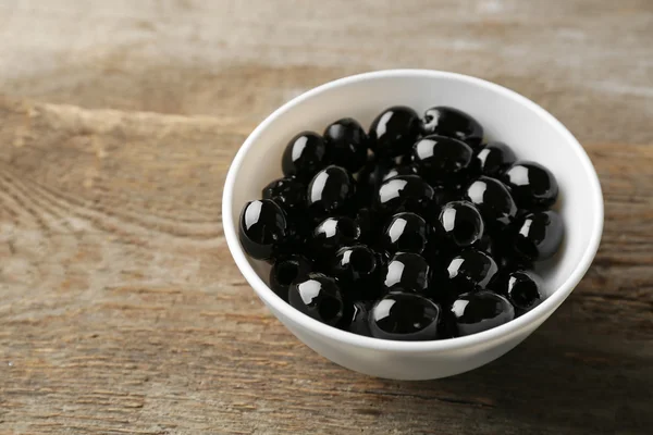 Aceitunas negras frescas en tazón blanco —  Fotos de Stock