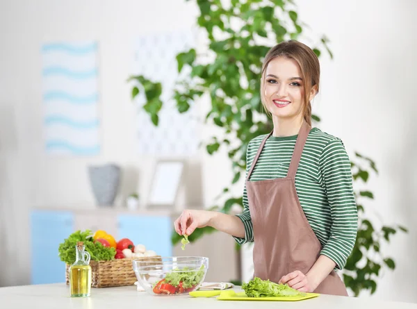 Mujer joven preparando ensalada de verduras — Foto de Stock