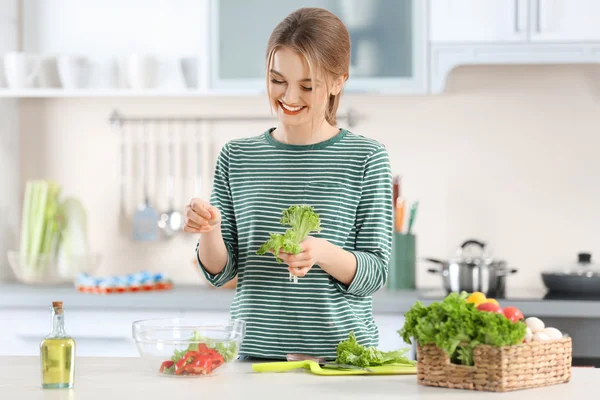 Junge Frau bereitet Gemüsesalat zu — Stockfoto