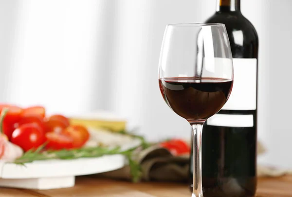 Copa y botella de vino tinto con comida —  Fotos de Stock