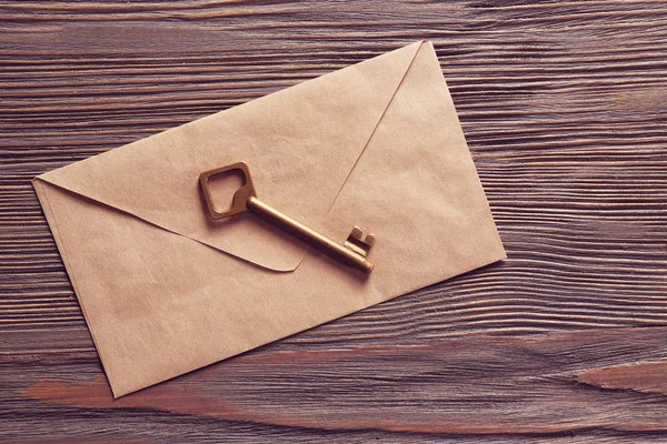Старый ключ с конвертом на фоне — стоковое фото