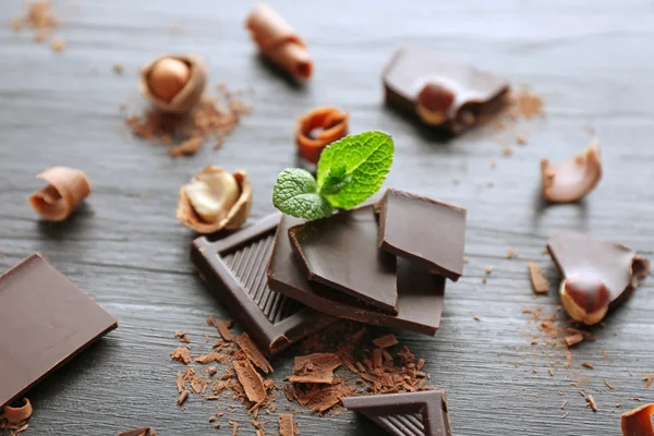 Bitar av choklad med hasselnötter och färska min — Stockfoto