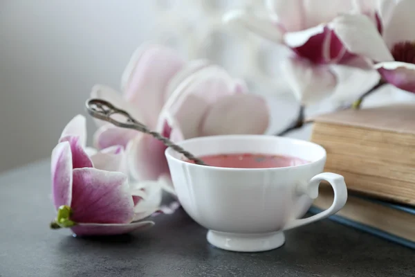 Kopp te med böcker och blommor — Stockfoto
