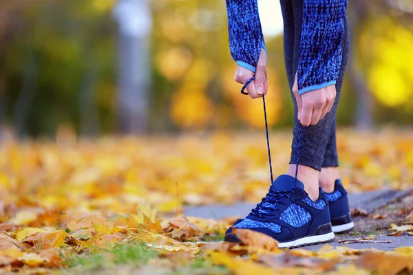 Woman in sportswear tying shoelaces