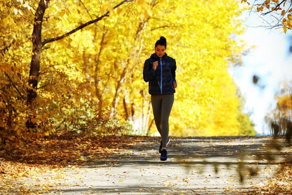 Vrouw joggen in herfst park — Stockfoto