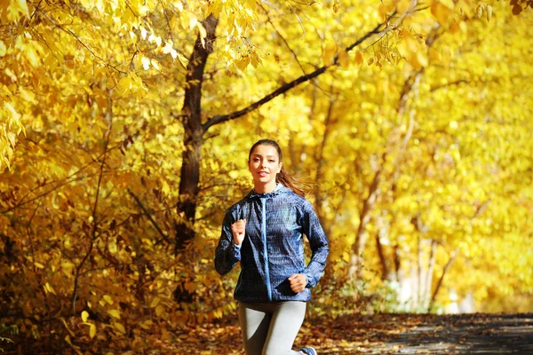 在秋天的公园慢跑的女人 — 图库照片