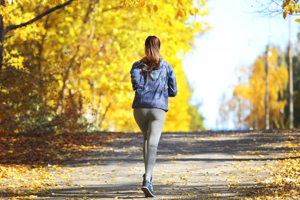 秋の公園でジョギングの女性 — ストック写真