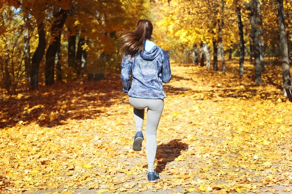 Жінка біжить в осінньому парку — стокове фото