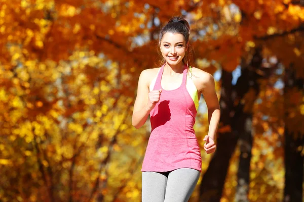 Vrouw joggen in herfst park — Stockfoto