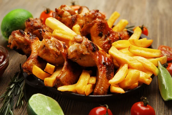 Baked chicken wings with French fries — Stock Photo, Image