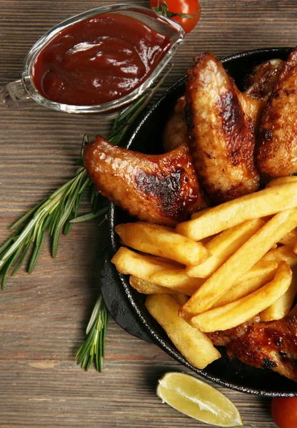 Ugnsbakad kycklingvingar med pommes frites — Stockfoto