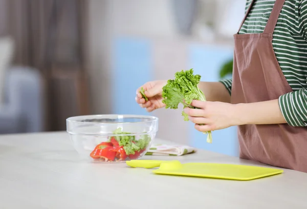 Jovem mulher preparando salada vegetal — Fotografia de Stock