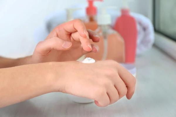 Hermosas manos femeninas aplicando crema — Foto de Stock