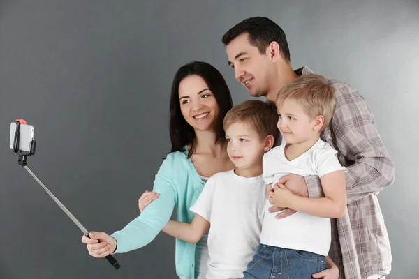 Familia Feliz Haciendo Selfie Con Palo Selfie Sobre Fondo Gris — Foto de Stock